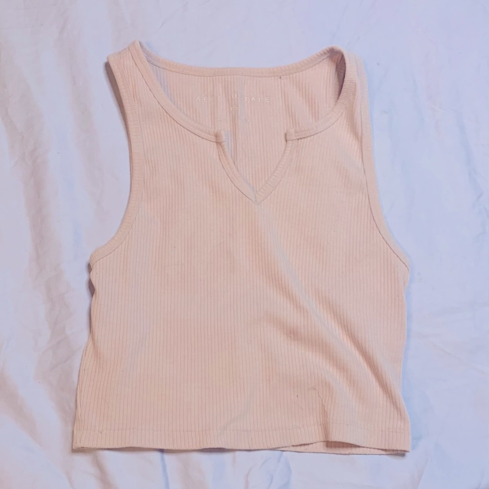 light pink, cropped, tank top that is mildly used